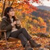 秋のキャンプ場で、紅葉を眺めながら焚き火にあたってくつろいでいる