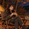 秋の夜のキャンプ場で、ランタンの明かりの下、静かにくつろいでいる