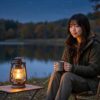 秋の夜の湖のほとりで、テントの前に座り、ランタンの明かりの下で静かにくつろいでいる