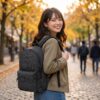 グレートスモーキーガーデンEX デイパックを背負って、秋の石畳や並木道のある街を楽しそうに歩いている
