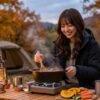 コンパクトノマドジャケットを着て、秋の夕方のキャンプ場で食事の準備をしている