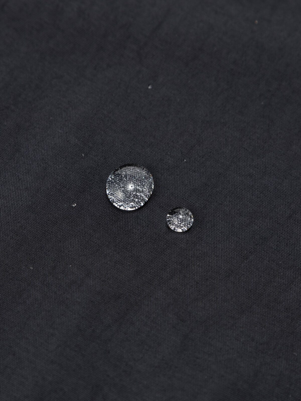 コンパクトノマドジャケットの表地で水をはじく様子