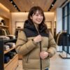 冬、高級感のあるアウトドアウェアの店内で、ヌプシフーディを試着している