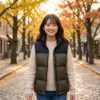 ヌプシベストを着て、秋の石畳や並木道のある街を楽しそうに歩いている