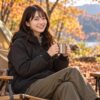 リバーシブルテックエアーフーディを羽織って、秋のキャンプ場でくつろいでいる