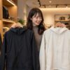 秋に、高級感のあるアウトドアウェアの店内で、コンパクトジャケットとベンチャージャケットを手に取って見比べている